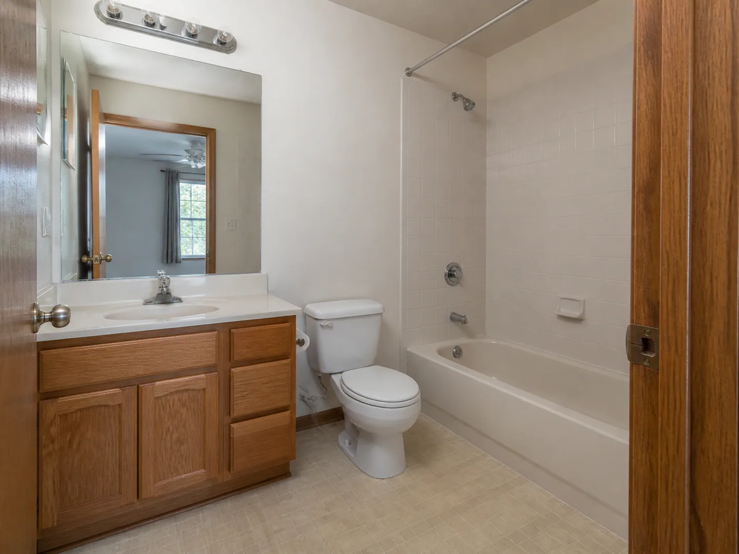 Dated hall bathroom with oak vanity and alcove tub